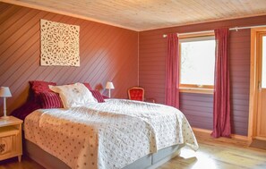 A bedroom with a bed, two bedside tables, a window with curtains, and a wooden ceiling. - Amazing home in Matredal with kitchen (Matredal)