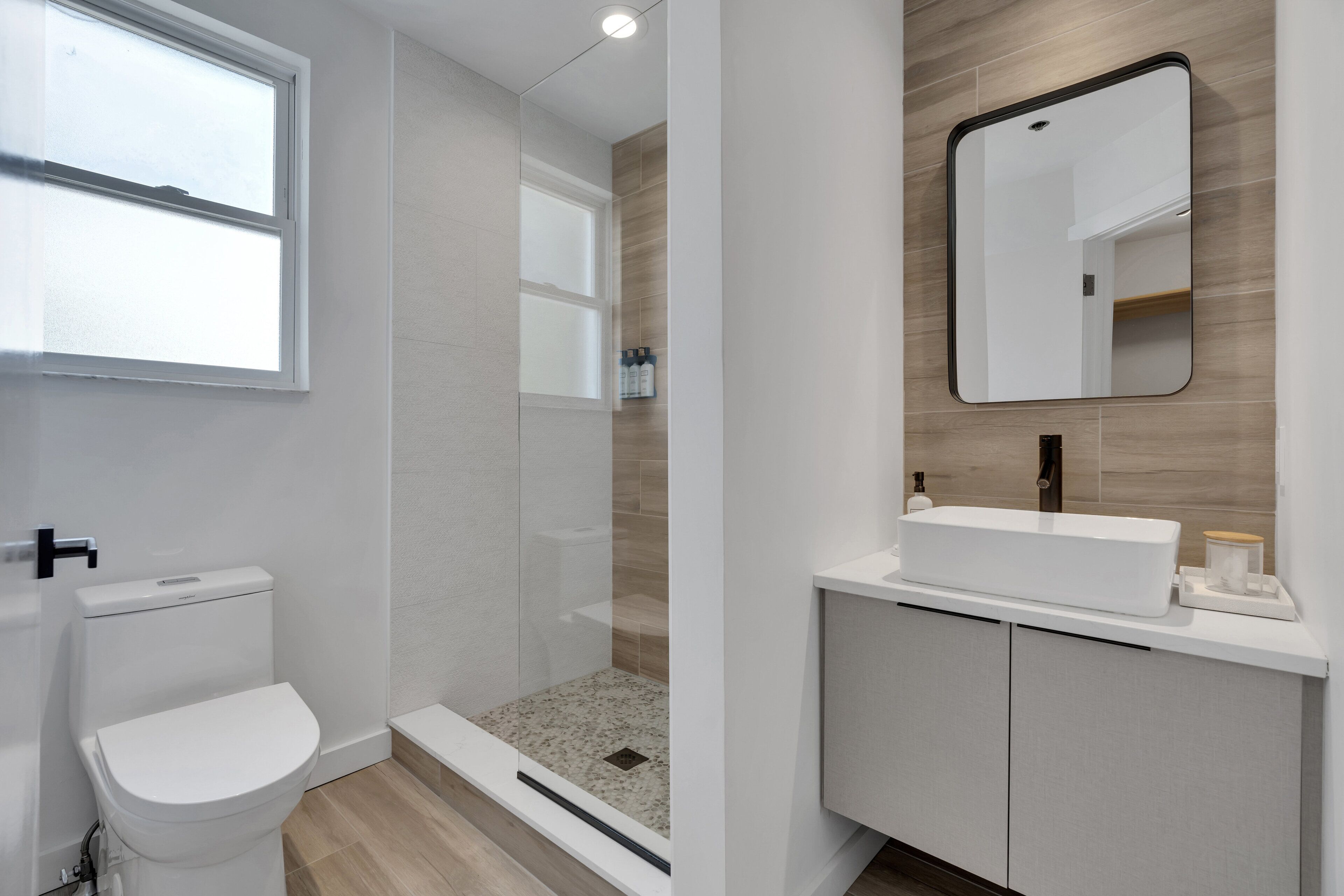 Un baño moderno con inodoro, ducha y lavamanos.