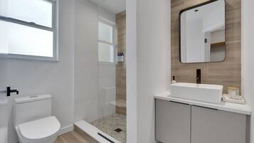 Un baño moderno con inodoro, ducha y lavamanos.
