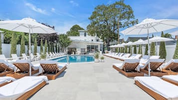 Una piscina al aire libre de temporada, sombrillas