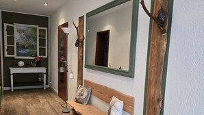 A hallway with a wooden bench, a mirror, and antler decorations. - Ferienwohnung mit Fantastischem Ausblick, Direkt am Wald (Walkenried)