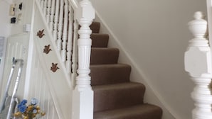 A staircase with white balusters and brown carpeted steps. - Impeccable 6-bed House in London (London)