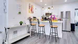 A modern kitchen with a central island, bar stools, pendant lighting, and stainless steel appliances. - ~ 4 Mi to Downtown Philadelphia: Cozy Retreat (Philadelphia)
