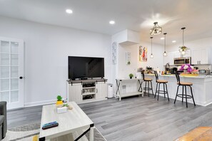 Relax in this stylish living space with a flat-screen TV, coffee table, and potted plant.