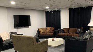 A modern living room with a flat-screen TV, two sofas, a coffee table, and a lamp. - Outlaw Lodge (Hatfield 1st Floor) ATV,SXS Offroad (Iaeger)