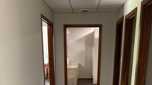 A hallway with carpeted floors and wooden doors leading to a bathroom with a sink and toilet. - Outlaw Lodge (Hatfield 1st Floor) ATV,SXS Offroad (Iaeger)