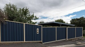 A gated property with a covered area, a metal gate, and a number '9' sign. - Walter Cottage: As Cosy as it is Convenient (South Launceston)