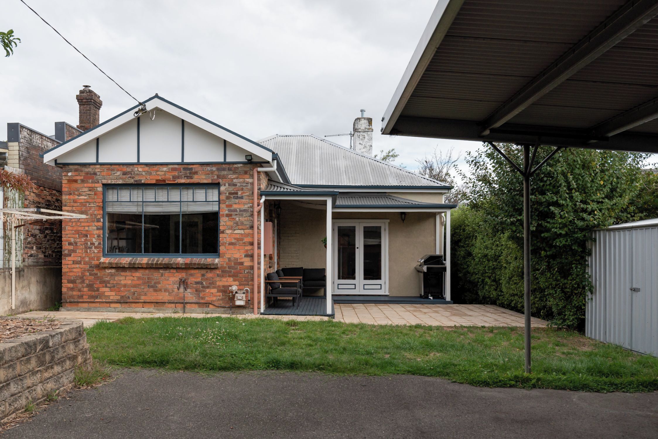 Une maison de plain-pied avec une façade en briques, un porche abrité et un garage.