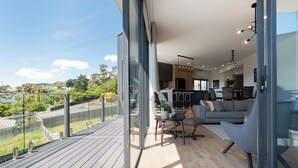 A modern living space with a balcony, a dining area, and a kitchen. - Impressively Spacious, Modern & Convenient (Newstead)