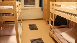 A room with two bunk beds, a window with blinds, a radiator, and a wooden wardrobe. - Peaceful holiday apartment on a small farm, Tørberget in Trysil (Innlandet)