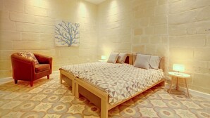 Ein Schlafzimmer mit einem Bett, einem Sessel und einem Nachttisch.