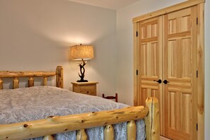 Cozy retreat with a comfortable bed, bedside table, and ample storage in a simple, functional space.
