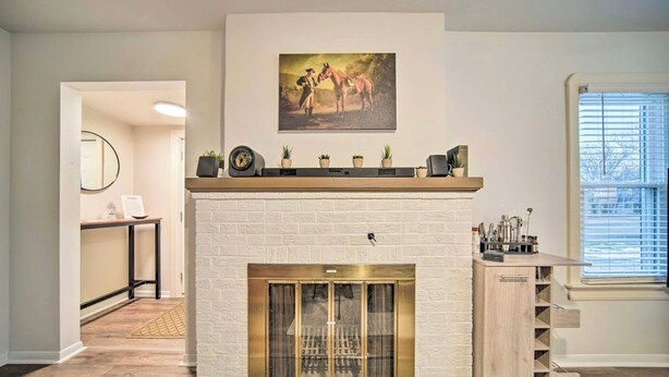 Un salon moderne avec une cheminée, un tableau accroché au mur et une petite table agrémentée d’objets décoratifs.