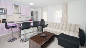 Een moderne keuken met een eethoek, een bank en een salontafel.