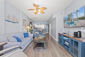 A living room with a sofa, coffee table, and a ceiling fan. - Crescent Keyes PH18-2BR/2BA Oceanfront-Pools (North Myrtle Beach)