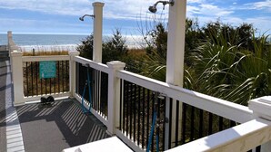 A balcony with a view of the ocean, a sign instructing to use the shoe/sand brush before entering the building, and a metal railing. - Crescent Keyes PH18-2BR/2BA Oceanfront-Pools (North Myrtle Beach)