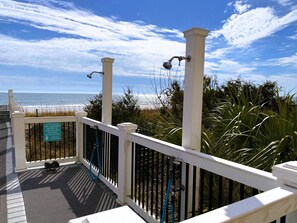 A balcony with a view of the ocean, a sign instructing to use the shoe/sand brush before entering the building, and a metal railing. - Crescent Keyes PH18-2BR/2BA Oceanfront-Pools (North Myrtle Beach)