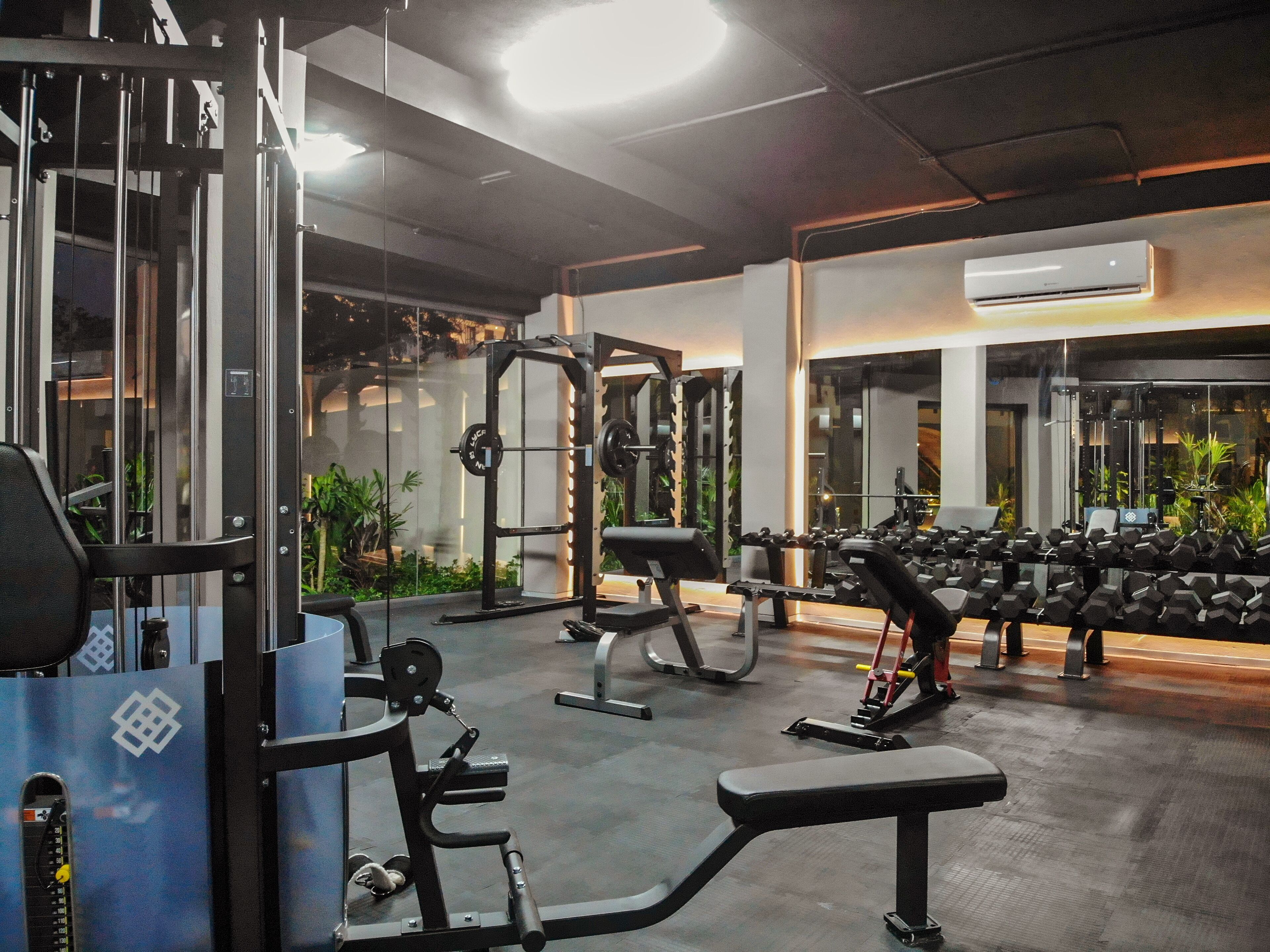 A gym with various exercise equipment, including weight machines and dumbbells.