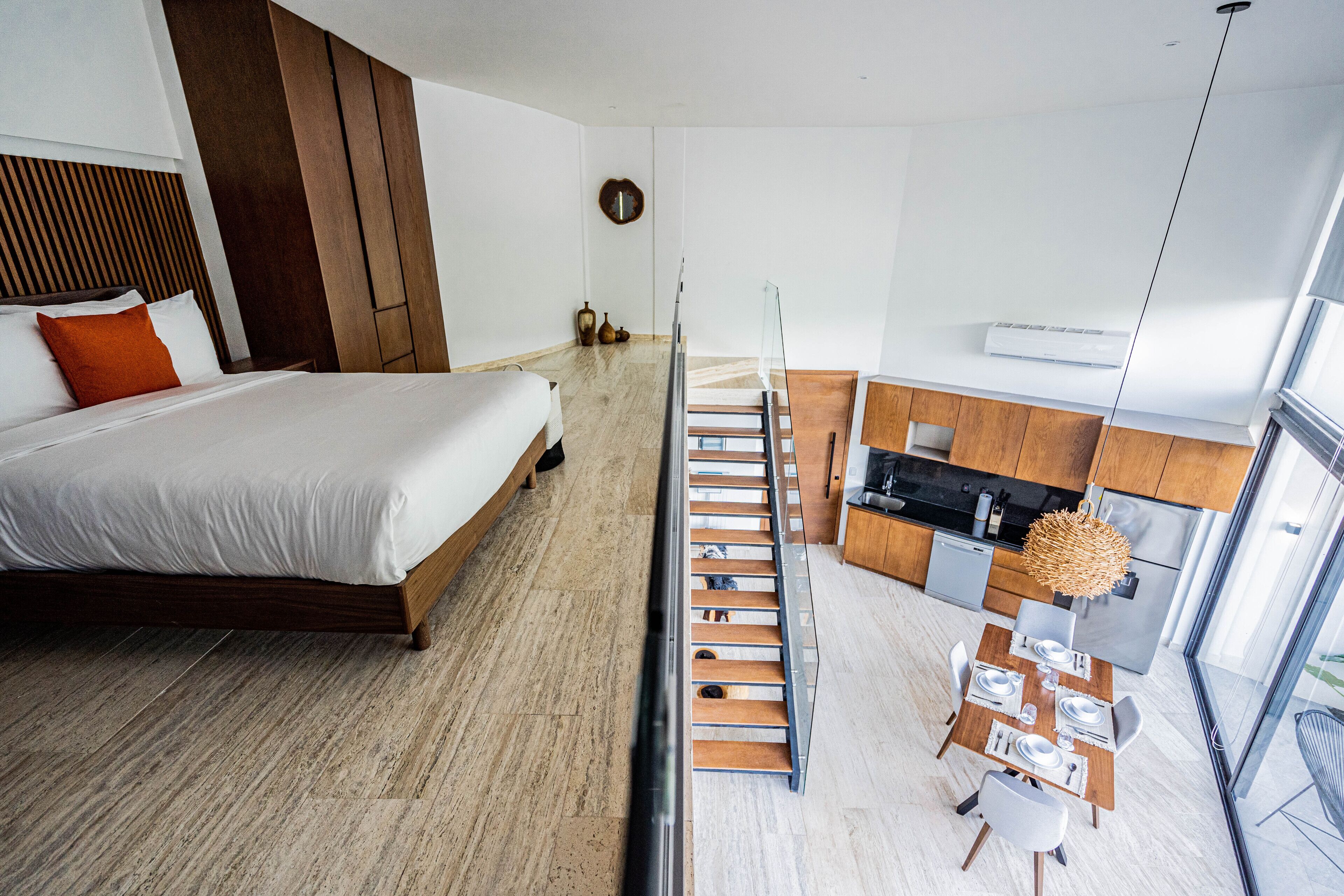 Een moderne hotelkamer met een bed, een eethoek en een keuken.