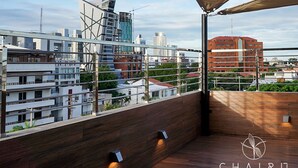 A rooftop terrace with a view of the city skyline, including modern buildings and construction cranes. - Chairú Eco Hotel (Santa Cruz)