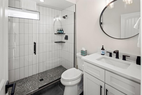 Un baño moderno con ducha, inodoro y lavamanos.