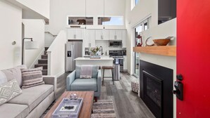 Un apartamento moderno con cocina, sala de estar y una pared roja de acento.