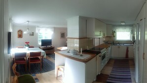 A compact kitchen with a dining area, a small island, and a window providing natural light.
