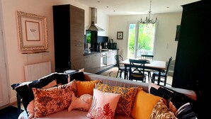 A modern living room with a sofa, dining table, and kitchen area. - The calm, the charm, the Maison du Menez: "the place to be" (La Forêt-Fouesnant)