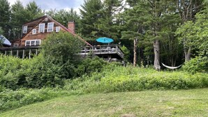 A rustic wooden house with a balcony overlooking a lush garden. - Year Round Mountain Retreat (Putney)