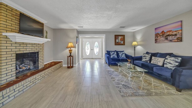 A living room with a fireplace, blue sofa, and a rug.