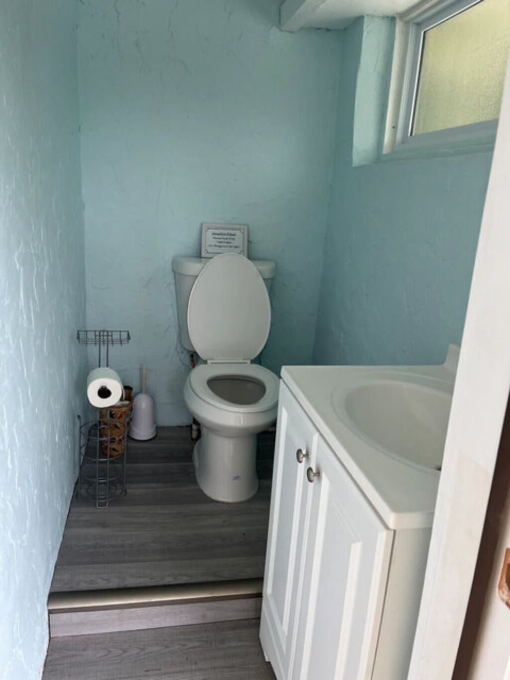 A small bathroom with a toilet, a sink, and a shower.