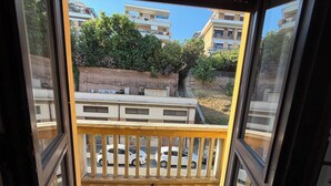 Een balkon met uitzicht op geparkeerde auto's en gebouwen.