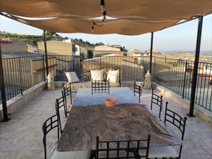 A terrace with a table and chairs, a pergola, and a view of the surrounding area. - Ravanusa small town with its typical Sicilian customs preserved (ravanusa)