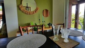Ruokapöytä, jossa on lautasliinat, korkea lasivaasi ja peili seinällä.