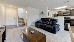 A living room with a leather sofa, a coffee table, and a staircase leading to another level. - Jarrell Jewel 💎 (Jarrell)