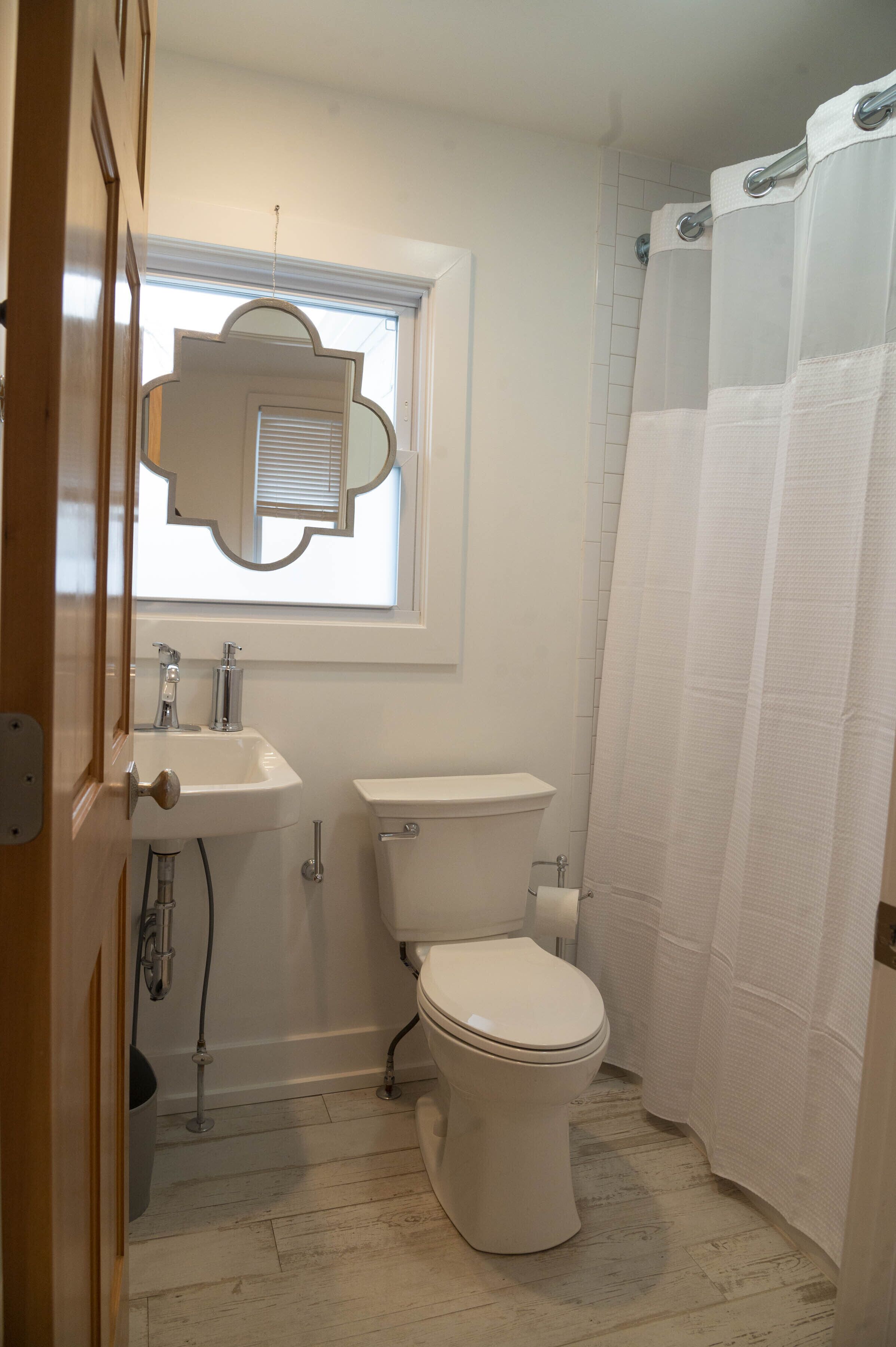 Un baño con inodoro, lavabo y ventana.
