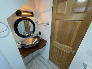 Een bad/douchecombinatie, een bubbelbad, een haardroger, handdoeken