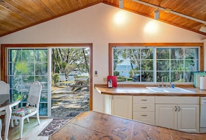 Una cocina con vista a un patio, una mesa de comedor y un ventanal que da al exterior.