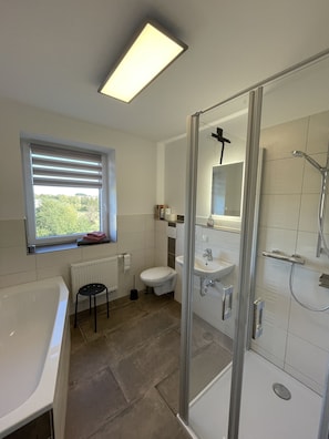 Bathtub, hair dryer, towels, toilet paper