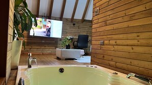 A modern spa area with a large bathtub, wooden walls, and pendant lighting. - Quimera Ecolodge Cabana - 7 min JMC Airport (Antioquia)