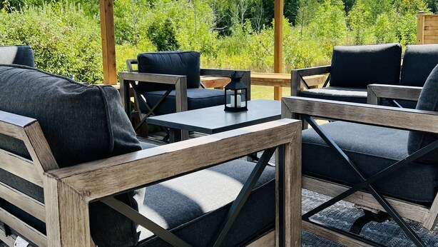 Un espace extérieur aménagé avec du mobilier en bois et une pergola.