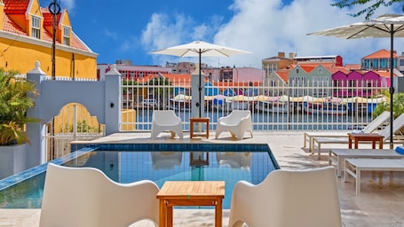 Una piscina al aire libre, sillones reclinables de piscina. Atelier Skalo Boutique Hotel