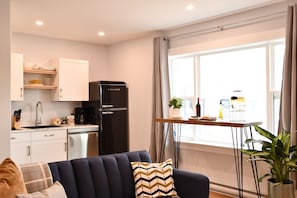A compact living space with a kitchenette, a dining area, and a sofa.