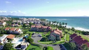 A resort with a pool, beachfront villas, and a view of the ocean. - Shell Beach House - Garden Unit, Steps to Beach! (Palmas del Mar)