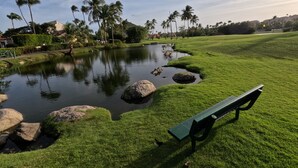 A park with a pond, rocks, and a bench. - Shell Beach House - Garden Unit, Steps to Beach! (Palmas del Mar)
