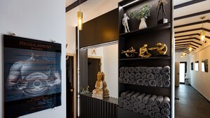 A wellness center with a poster detailing regulations, a reception desk with a Buddha statue, and shelves with rolled towels. - Hotel Korona (Sighisoara)