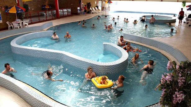 Une piscine intérieure dotée de plusieurs couloirs et d’un îlot central.
