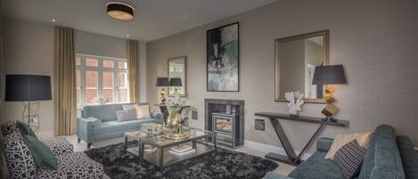 Una sala de estar moderna con sofá, sillón, mesa de centro, chimenea y un espejo grande.