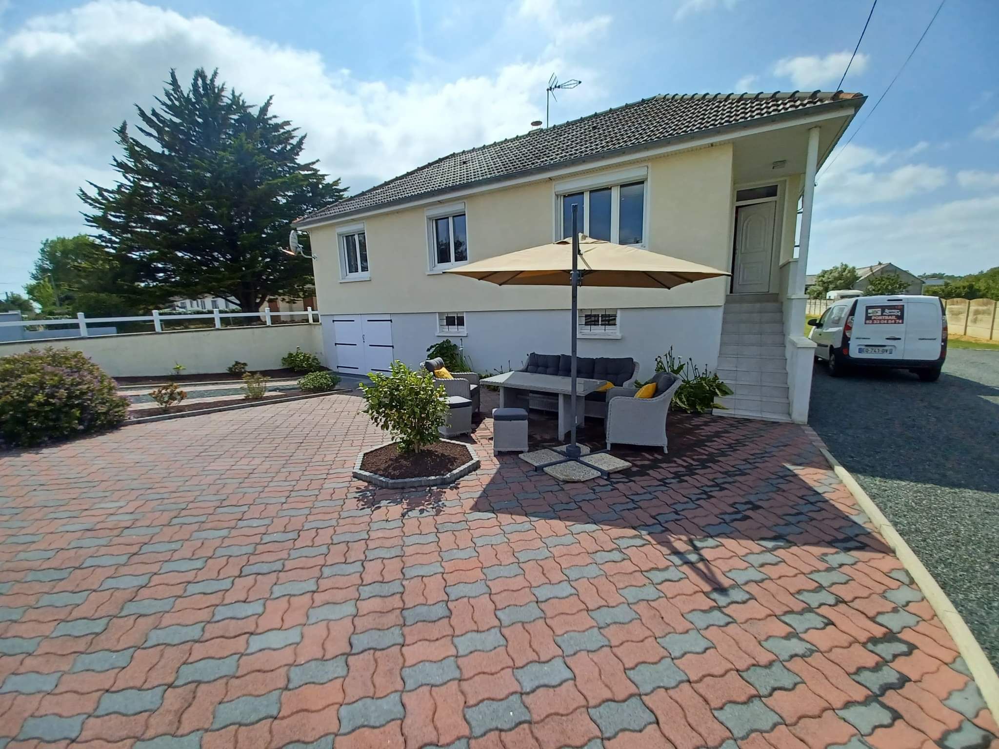 A house with a patio area featuring outdoor furniture and a table.