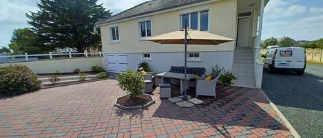 A house with a patio area featuring outdoor furniture and a table.